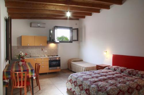 een slaapkamer met een bed en een tafel en een keuken bij Villa Giovanna in Nardò