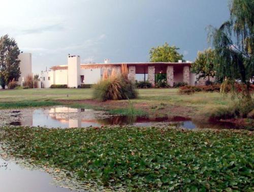 a building next to a pond in front of a building at Hotel Boutique Posada Piedras Blancas in Santa Rosa