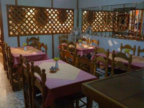 un restaurante con mesas y sillas con manteles púrpuras en Kythereia Hotel, en Agia Pelagia - Citera