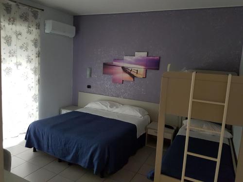 a bedroom with a bed and two bunk beds at Hotel Piccolo Paradiso in Bordighera
