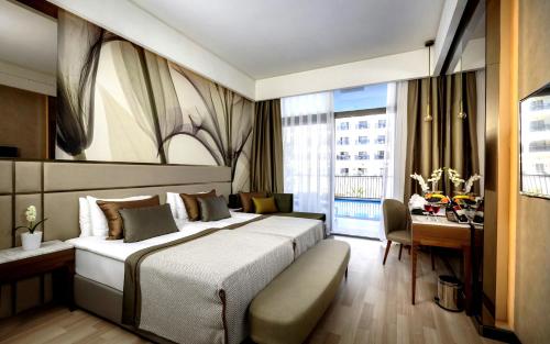 una camera d'albergo con un letto grande e una scrivania di Riolavitas Resort & Spa a Side