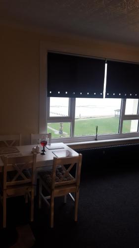 a room with a table and two chairs and a window at Seabreeze in Littlestone-on-Sea