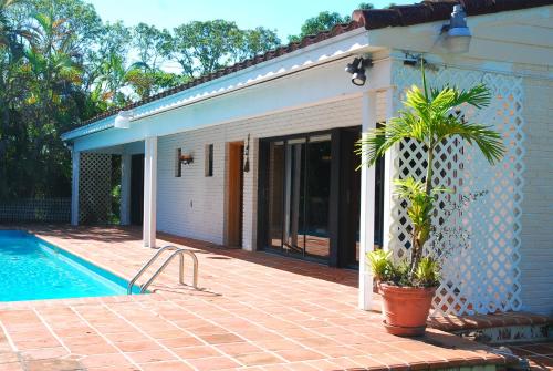 una casa con una maceta junto a una piscina en La Finca, en Miami