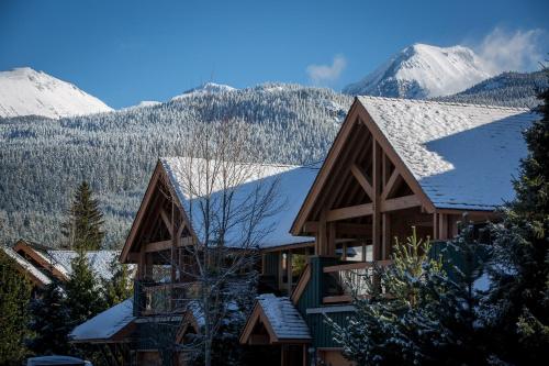 a house covered in snow with mountains in the background at Montebello by Whistler Premier in Whistler