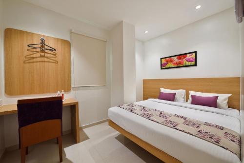 a hotel room with a bed and a desk at Hotel Leafio-Near Airport in Mumbai