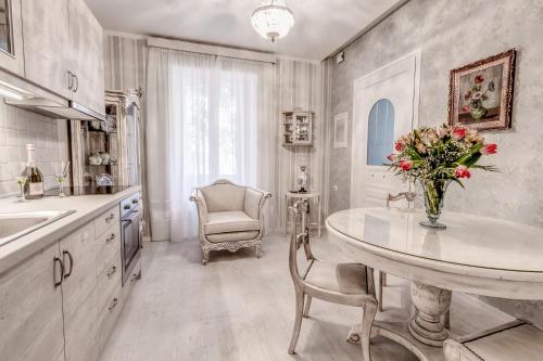 una cucina con tavolo e vaso di fiori di Papalina Suite a Città di Corfù