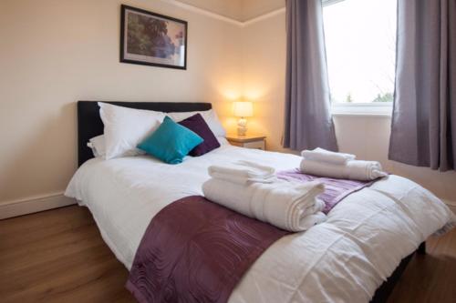 a bedroom with a large bed with towels on it at Westfield House in Hinckley