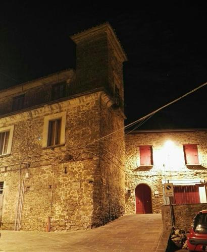 a stone building with a red door at night at Appartamento Perito in Perito