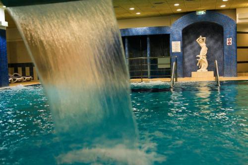a water fountain in a building with a statue at Ensana Sovata in Sovata