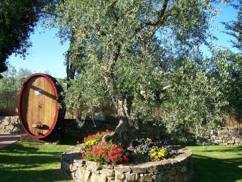 a tree in a stone planter with flowers at Hotel Belvedere Di San Leonino in Castellina in Chianti
