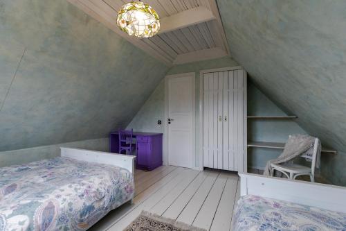 a attic bedroom with a bed and a chair at House in the City in Tallinn