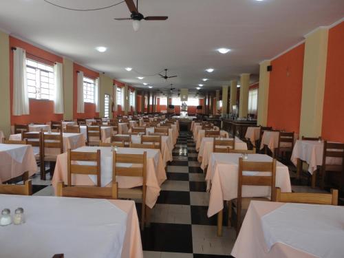 a dining hall with tables and chairs and a ceiling at Jóia Hotel in Poços de Caldas