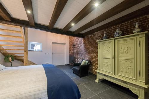 a bedroom with a bed and a brick wall at Op Geneijgen in Grathem