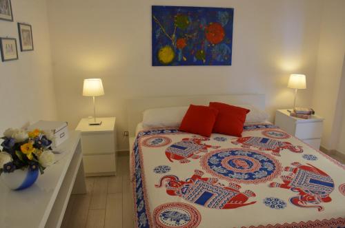 1 dormitorio con 1 cama y un jarrón de flores en Terrazza sul Mare, en Giardini Naxos