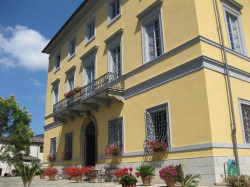 a yellow building with flowers on the balconies at B&B Villa Pardi Lucca in Lucca