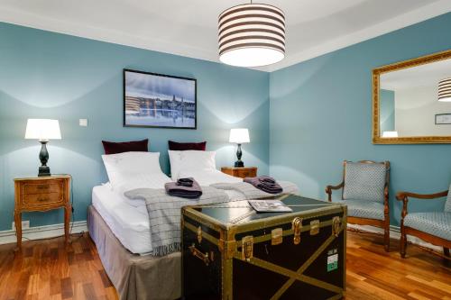 a bedroom with blue walls and a bed with a trunk at Freyja Guesthouse & Suites in Reykjavík
