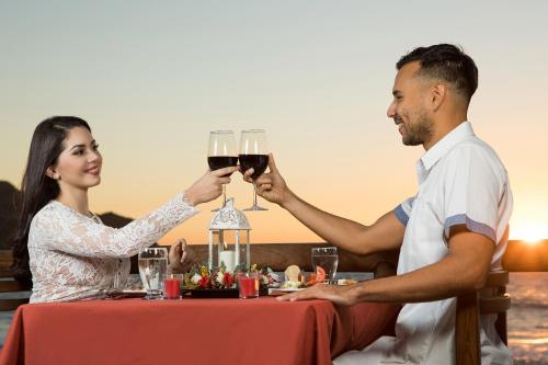 a man and a woman holding glasses of wine at Costa de Oro Beach Hotel in Mazatlán