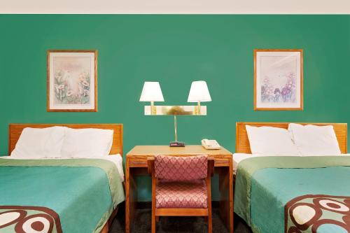 a room with two beds and a table with a chair at Spark by Hilton Carlisle South in Carlisle