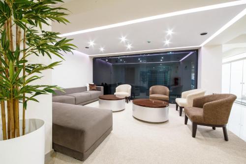 a living room with a couch and chairs and a table at Hotel Solec in Chiclayo