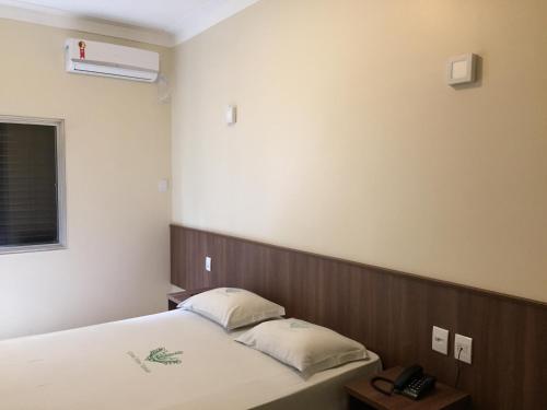 Grand Hotel Taboao tesisinde bir odada yatak veya yataklar