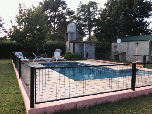 a swimming pool with a fence around it at Complejo Leon in Villa Rumipal