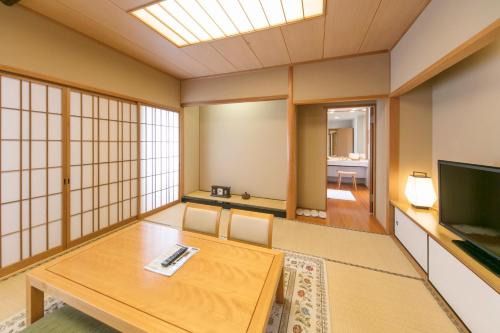 a living room with a table and a television at Kobe Seishin Oriental Hotel in Kobe