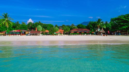 a beach with a group of resorts and the water at Sita Beach Resort in Ko Lipe