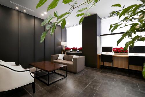 a living room with a couch and a table at Arban City Hotel in Busan