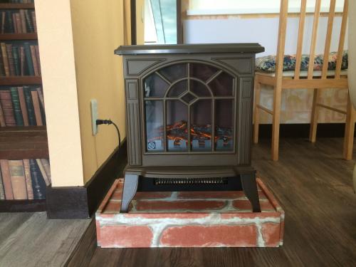 a wood stove in a room with a staircase at South Island in Itoman