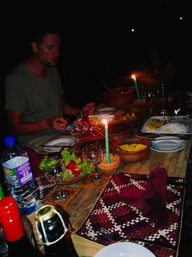 a man sitting at a table with a table with candles at 360 Rainforest in Deniyaya