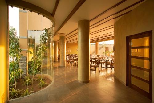 a dining room with tables and chairs in a building at Dera Masuda Luxury Resort in Pushkar