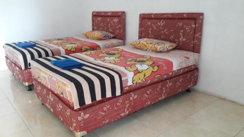 dos camas sentadas una al lado de la otra en una habitación en Bamboo House, en Pangandaran