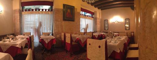 a dining room with tables with red and white table settings at Hotel Gabbia D'Oro in Verona