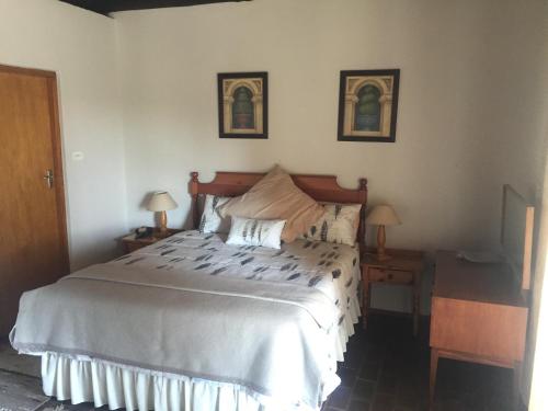 sypialnia z dużym łóżkiem z dwoma lampami i dwoma stołami w obiekcie Lairds Lodge w mieście Underberg