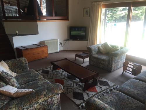 a living room with two couches and a tv at Lairds Lodge in Underberg