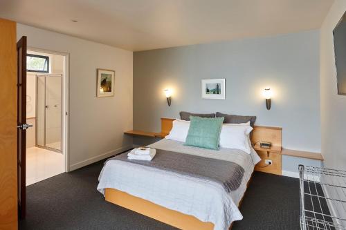 a bedroom with a bed with a green pillow at Tamar River Apartments in Rosevears