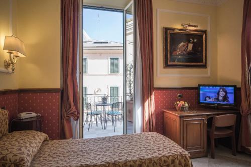 ローマにあるホテル ドナテッロのベッド、テレビ、バルコニーが備わるホテルルームです。