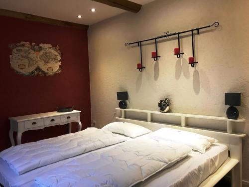 a bedroom with a white bed and a table at Haus Talblick in Barbis