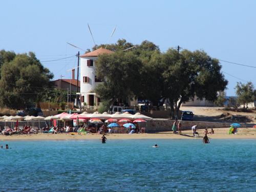 a group of people on a beach with umbrellas at Anni House in Stavros in Stavros
