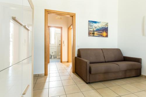 a living room with a brown couch in a room at Complesso Gardencasa in Torre Suda