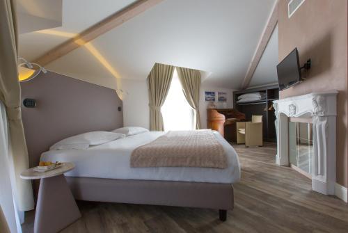 a bedroom with a large bed and a window at Hotel Al Campanile - Luxury Suites & Apartments in Baveno