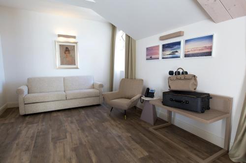 a living room with a couch and a chair at Hotel Al Campanile - Luxury Suites & Apartments in Baveno