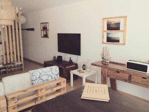 a living room with a couch and a tv at EsposendeGuesthouse in Esposende