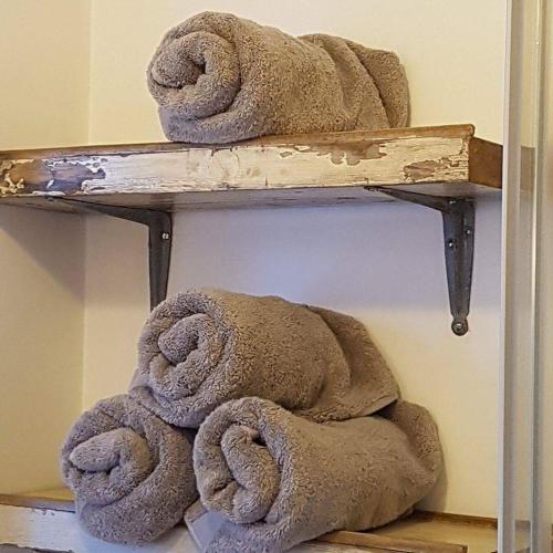 a pile of towels sitting on a shelf at Dilkara Apartment Glastonbury in Glastonbury