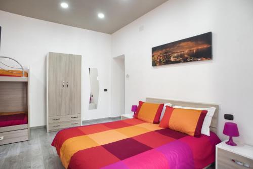 a bedroom with a bed with a colorful blanket at La Casa di Luna in Naples