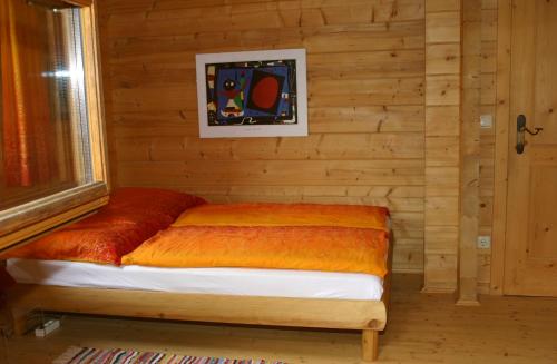 Bett in einem Zimmer mit einer Holzwand in der Unterkunft Holzhaus im Grünen B&B in Passau