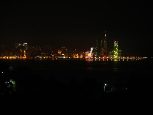 a city lit up at night with a city at Villa Royal House in Makhinjauri