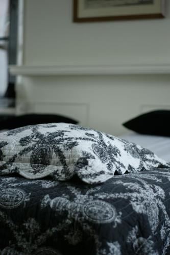 a black and white blanket on top of a bed at Auberge de Campveerse Toren in Veere
