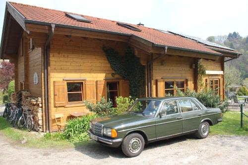 ein grünes Auto, das vor einem Haus parkt in der Unterkunft Holzhaus im Grünen B&B in Passau