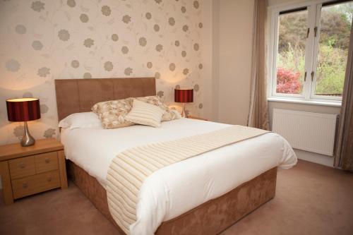 Un dormitorio con una cama grande y una ventana en Berehaven Lodge, en Castletownbere